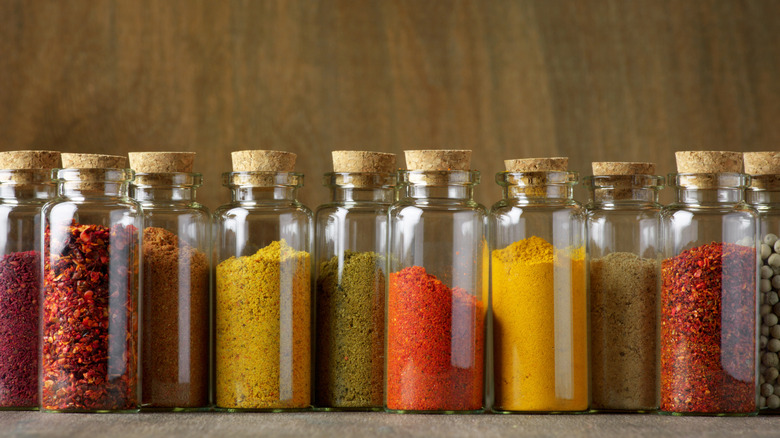 Bottles containing a variety of seasonings and spices.