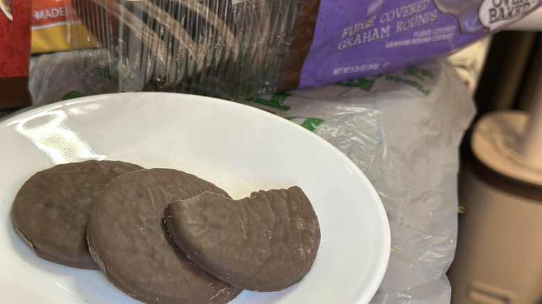Three Fudge Covered Graham Rounds from Dollar Tree on a plate with a bite taken out of one.