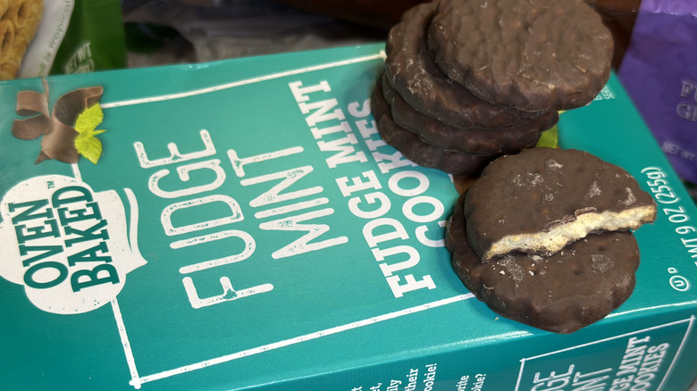 Several Oven Baked Fudge Mint Cookies stacked on package from Dollar Tree, with one cookie broken in half