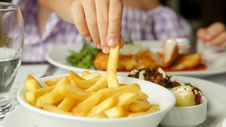 Little girl is eating french fries