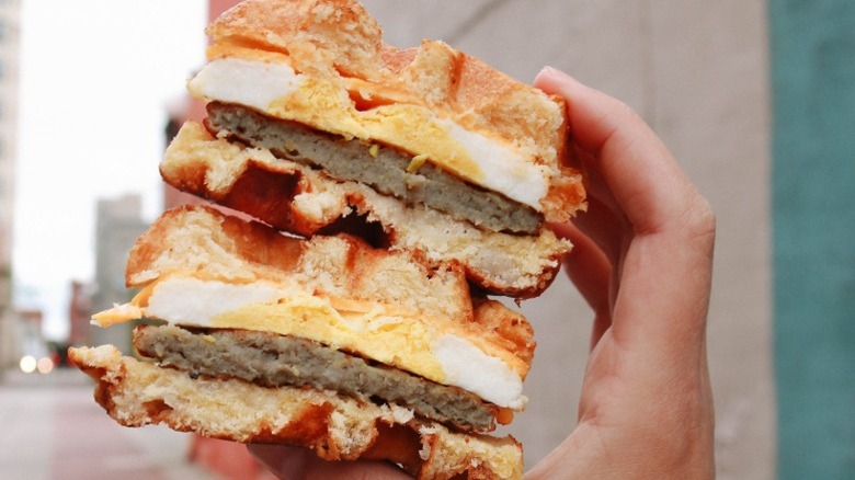 hand holding a Kwik Trip waffle breakfast sandwich