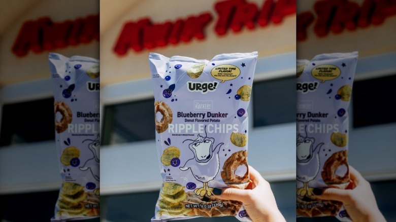 hand holding a bag of Blueberry Dunker Urge chips in front of a Kwik Trip