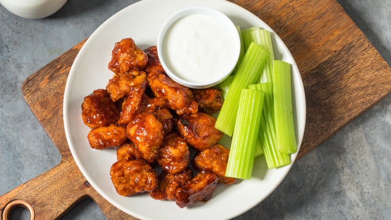 Buffalo wings with a side of ranch dressing for dipping.
