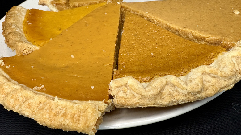 Multiple slices of pumpkin pie on a white plate