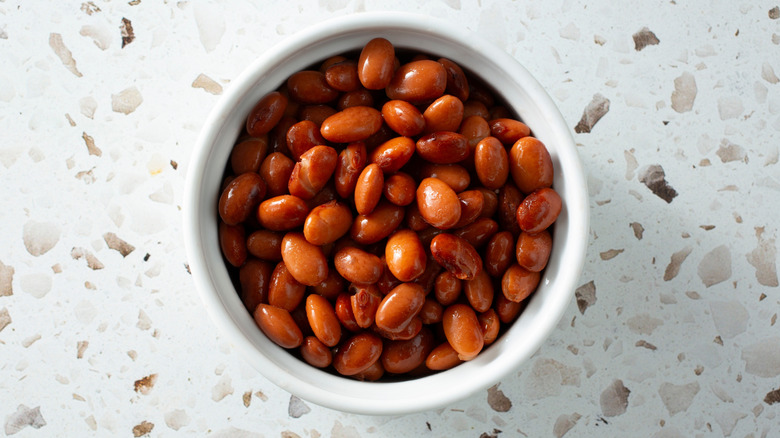 A white bowl filled with canned pinto beans