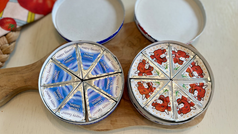 Open boxes of Aldi Happy Farms and Laughing Cow cheese wedges