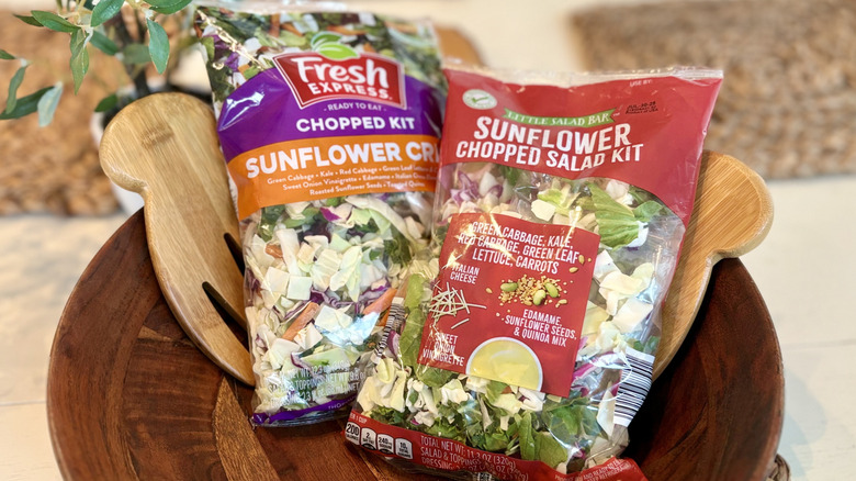 A wooden salad bowl with Fresh Express and Aldi sunflower salad kits
