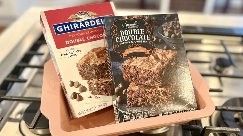 A baking pan with boxes of Ghirardelli and Aldi Specially Selected brownie mixes