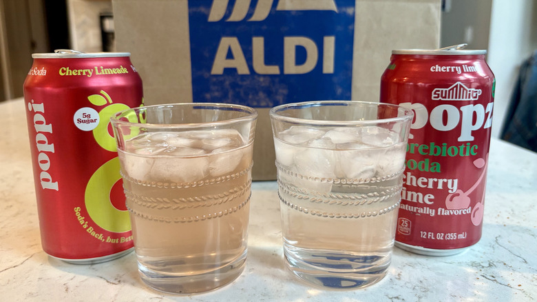 Cans and glasses comparing Poppi and Aldi Summit Popz prebiotic sodas
