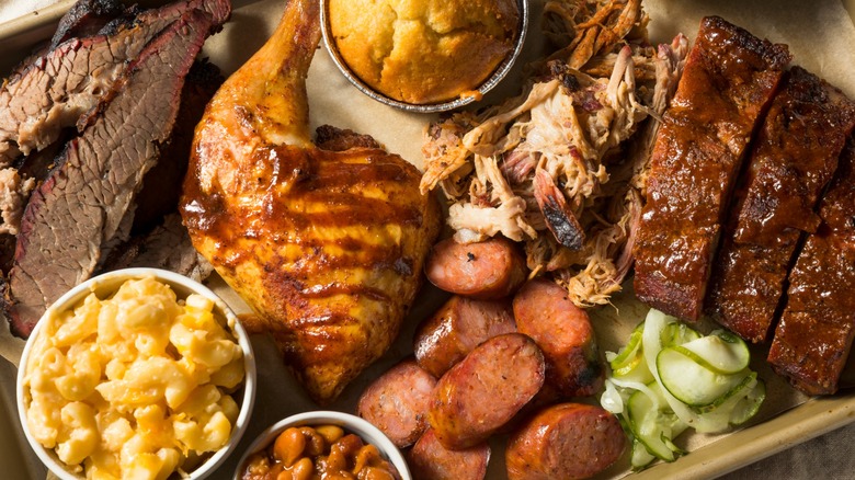 Barbecue plate with brisket, pulled pork, chicken, sausage, cornbread, mac, and beans