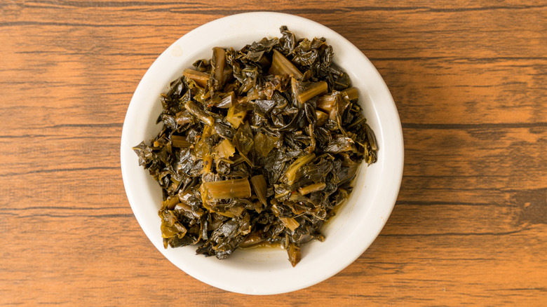 White plate of collard greens on a table