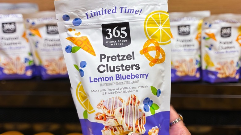 hand shown holding packet of 365 Whole Foods Market brand Lemon Blueberry Limited Edition Pretzel Clusters