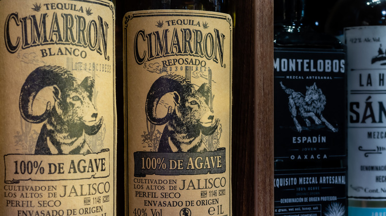 Two bottles of Cimarron tequila lined up on a shelf.