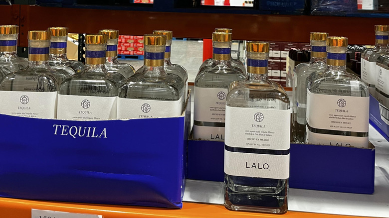 Several bottles of Lalo brand tequila sit in a row on a Costco shelf.