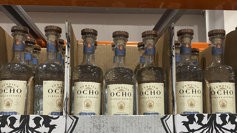 A row of Tequila Ocho bottles on a shelf at Costco.