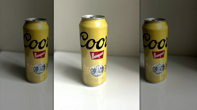 Large can of Coors Banquet beer on table, mirrored