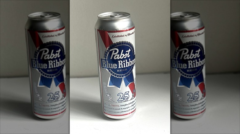 Tall can of Pabst Blue Ribbon beer on a white background on table, mirrored