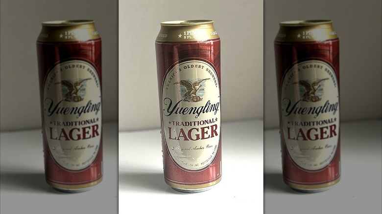 Tall can of Yuengling lager against a white background on table, mirrored