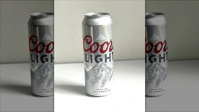 Tall can of Coors Light on a white background on table, mirrored