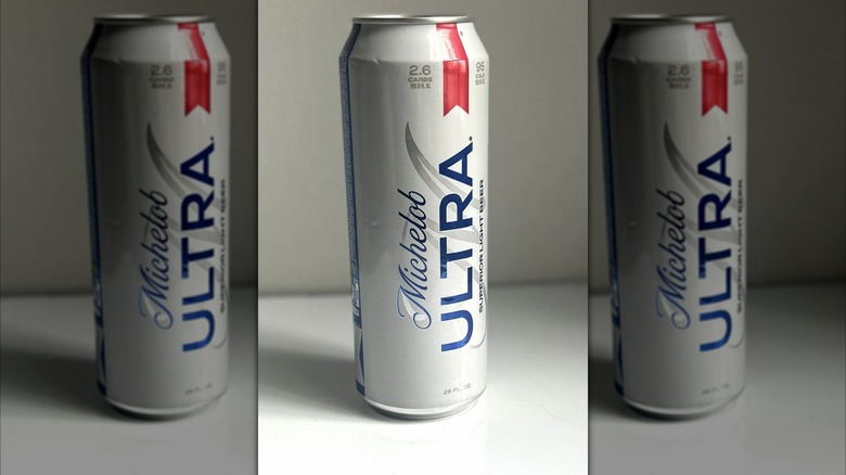 Tall can of Michelob Ultra beer on a white background on table, mirrored