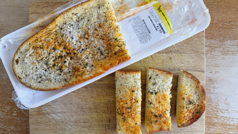Kroger half garlic bread loaf in its packaging beside a few individual slices