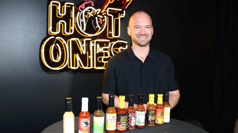 Sean Evans, the host of "Hot Ones," with hot sauce bottles