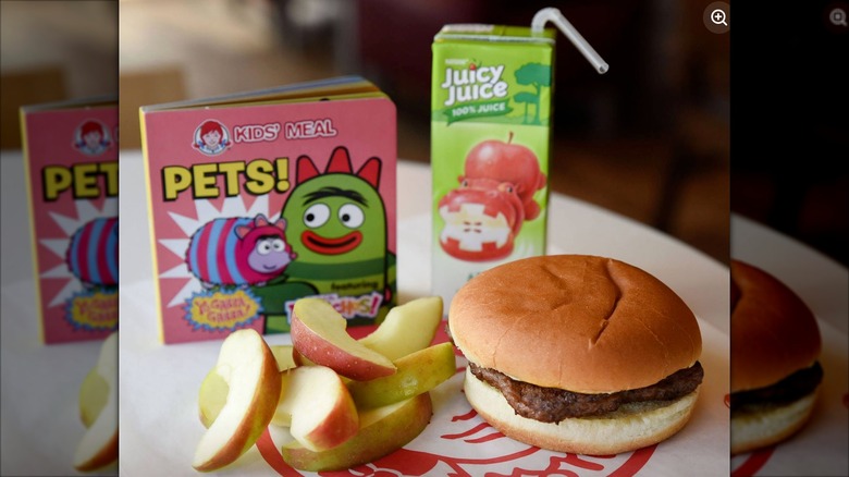 Wendy's kids meal complete with Juicy Juice apple juice, a hamburger, apple slices, and a book about pets