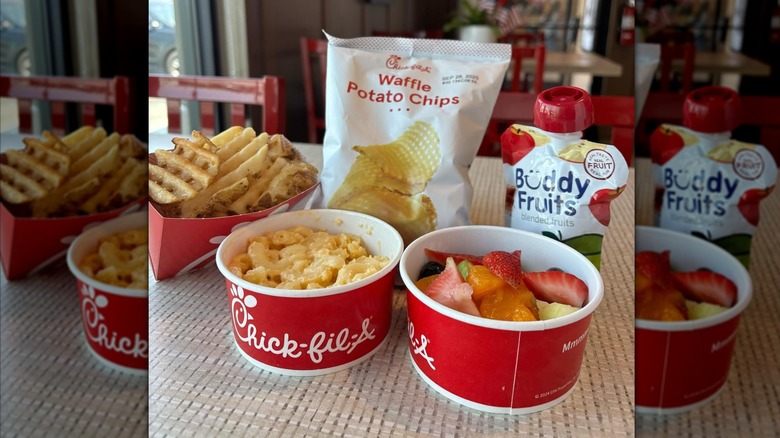 Chick-fil-A Kid's Meal on chick-fil-a restaurant table featuring fruit, mac and cheese, waffle fries, potato chips, and fruit drink