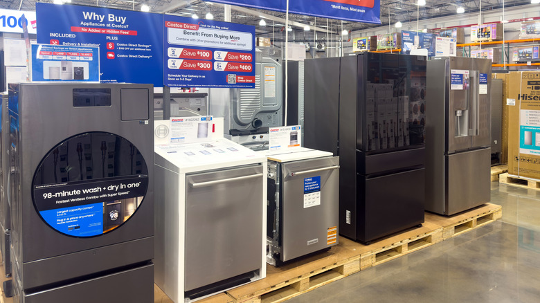 A washer/dryer, two dishwashers, and two refrigerators on the pallets at Costco