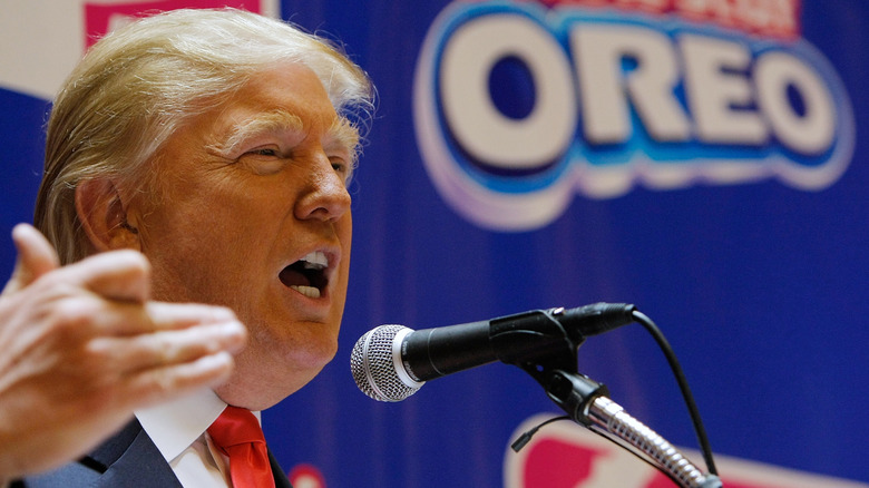 Donald Trump speaking at a podium in front of an Oreo backdrop
