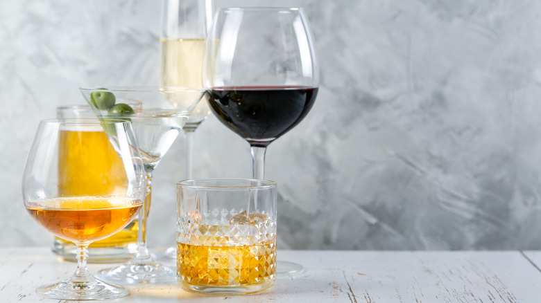 Assorted alcoholic drinks including a glass of red wine, martini with olives, and glasses of spirits