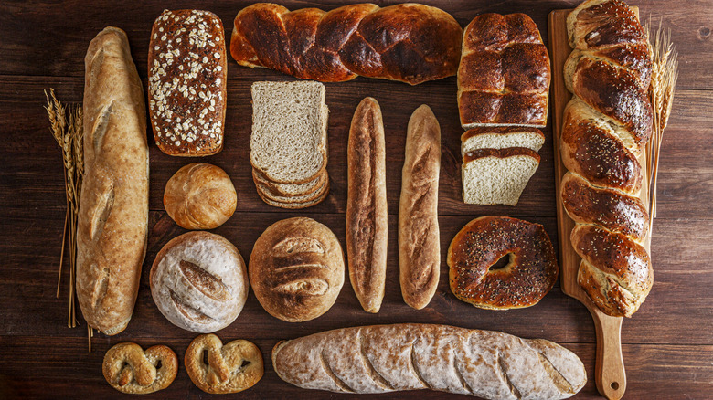Top view of assorted types of bread on a wooden table