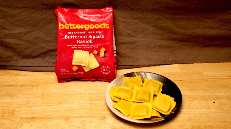 A cooked plate of Bettergoods brand Butternut Squash Ravioli placed beside the bag it came in