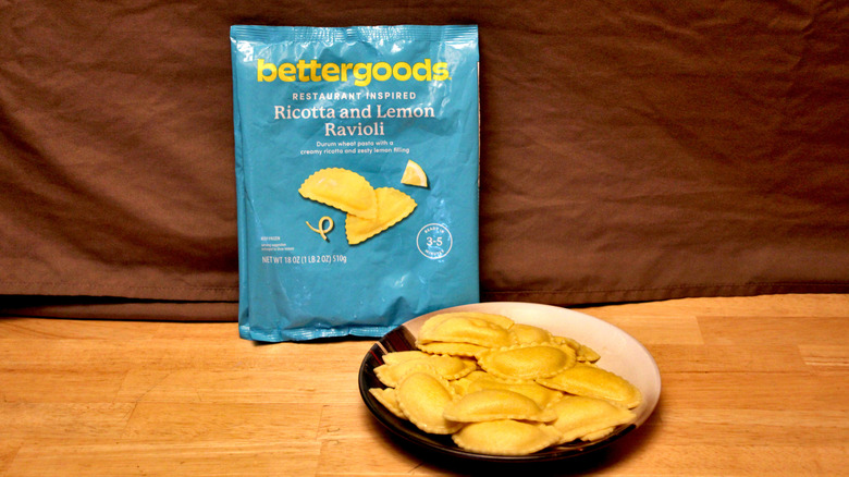 A cooked plate of Bettergoods brand Ricotta and Lemon Ravioli placed beside the bag it came in