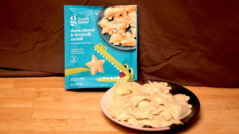 A cooked plate of Good & Gather brand Three Cheese & Broccoli Ravioli placed beside the bag it came in