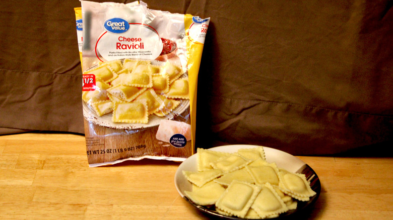 A cooked plate of Great Value brand Herb Cheese Ravioli placed beside the bag it came in