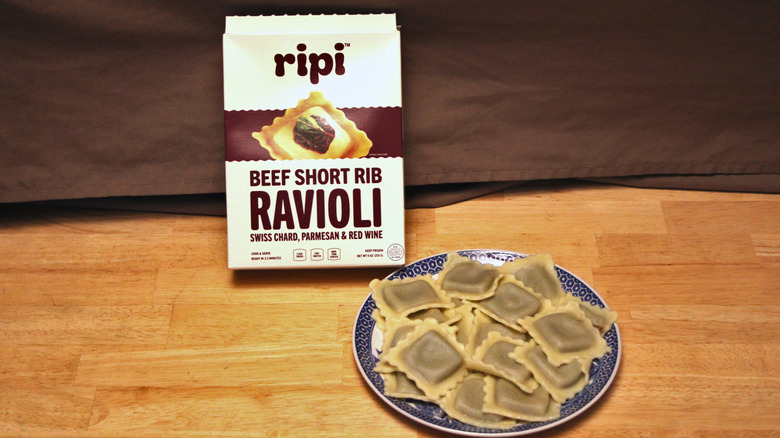 A cooked plate of Ripi brand Beef Short Rib Ravioli placed beside the box it came in