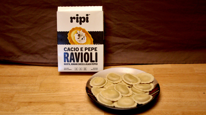 A cooked plate of Ripi brand Cacio e Pepe Ravioli placed beside the box it came in