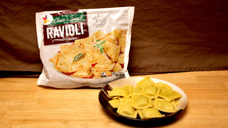 A cooked plate of Stop & Shop brand Cheese & Spinach Ravioli placed beside the bag it came in