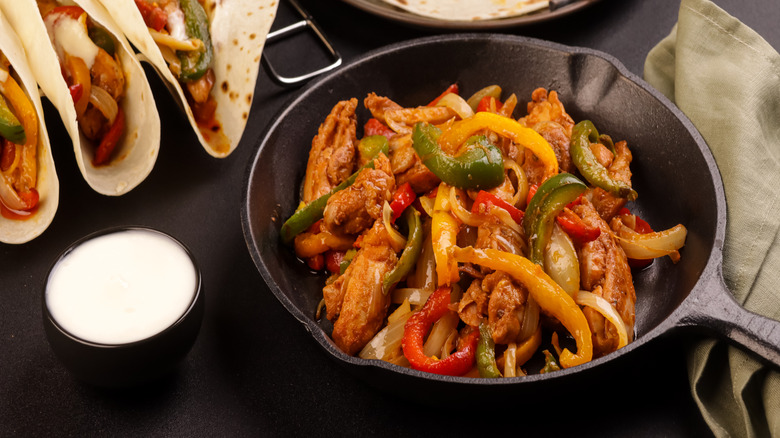 Fajitas in skillet with flour tortillas
