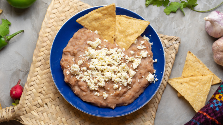 Plate of refried beans with chips and cheese