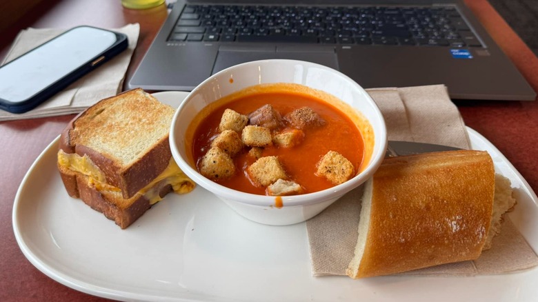 Tomato soup on plate with grilled cheese and bread