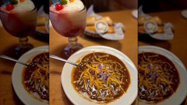 Bowl of chili with cheese and frosty drink