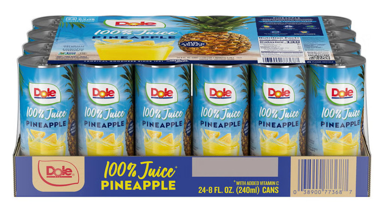 Multiple cans of Dole 100% Pineapple Juice in a case on a white background