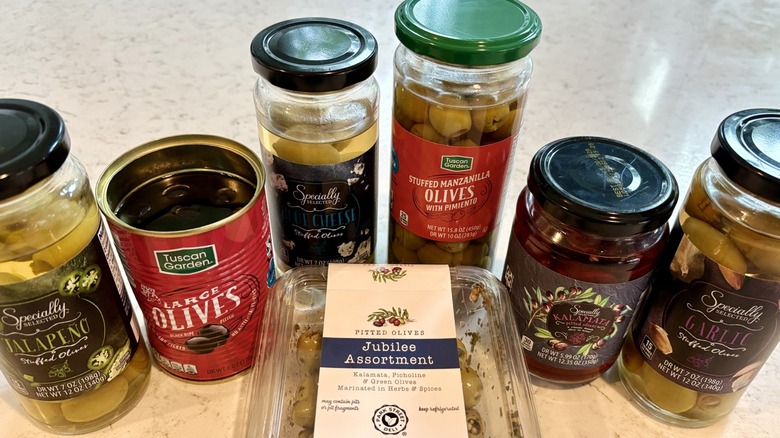 An assortment of jar, can, and refrigerated olives available at Aldi