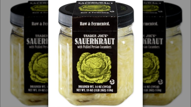 Glass jar of Sauerkraut with Pickled Persian Cucumbers from Trader Joe's on white background