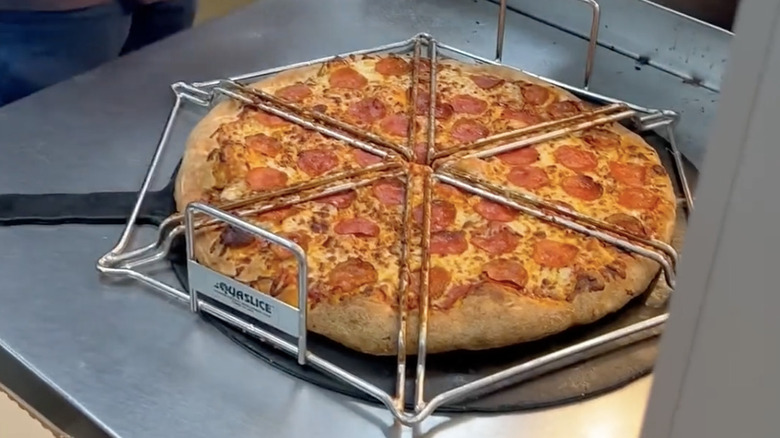 The cutting guide that Costco uses to cut pizza placed on top of a whole pie