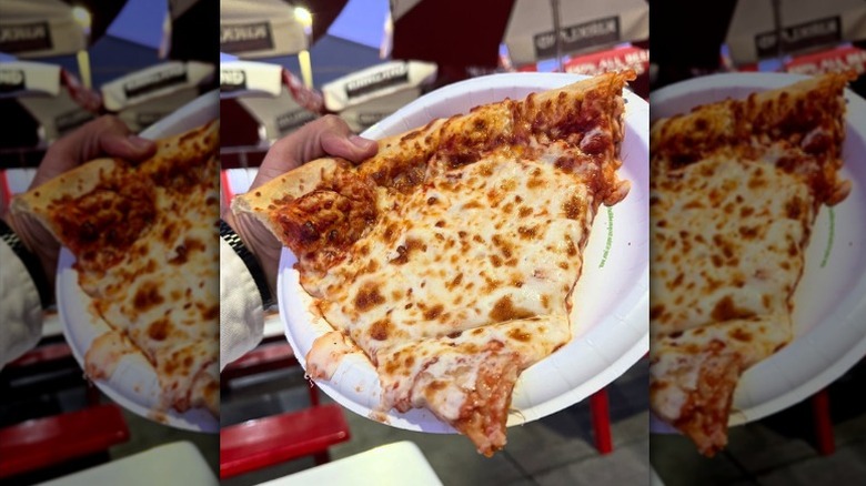 A single slice of Costco pizza overflowing with cheese on a plate