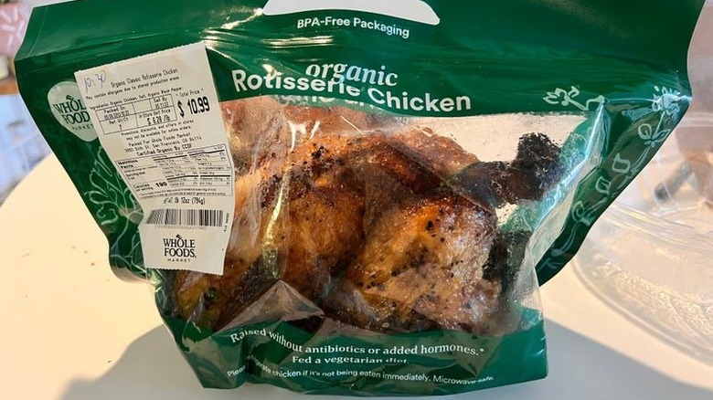 Green plastic bag with an organic rotisserie chicken