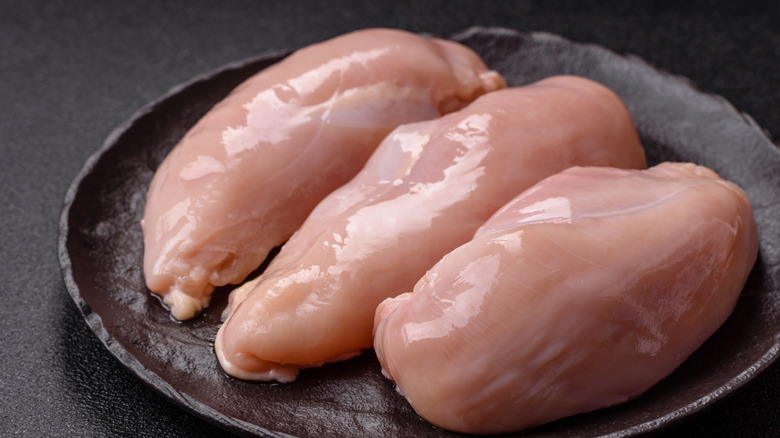 Raw chicken on a dark plate